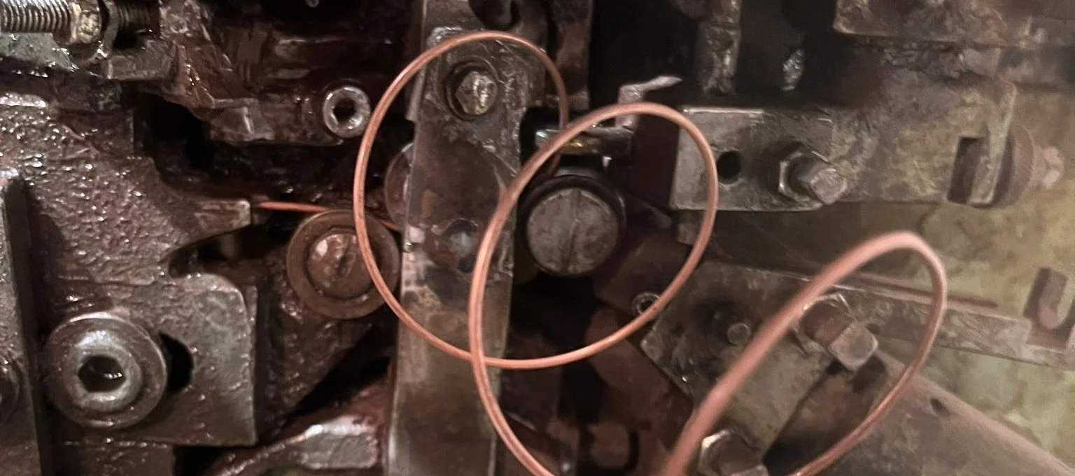Feder aus verkupfertem Federstahldraht wird am Federwindeautomaten der FK Manufaktur gewunden